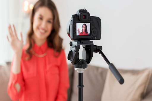 A woman recording video through camera